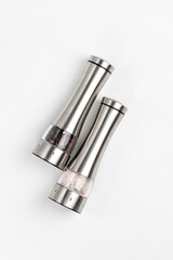 Two electric spice mills for salt and pepper. Metal. On a white table
