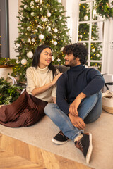 Woman touching man looking at each other sitting on floor