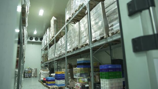 Yerevan, Armenia - September, 2021: Boxes of groceries in a industrial food large cold storage safety refrigerators. Panoramic shot. Slow Motion 