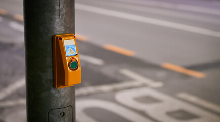 Press to cross the street. Detail of this object which helps pedestrians for crossing the streets. It is placed next to a bus station.