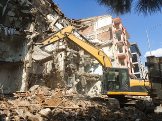 Building demolition excavator with long mechanical arm. Destruction of a house. Heavy machinery, hydraulic construction equipment.