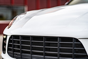 Fototapeta na wymiar Compact white executive car, business car, large chrome grille.