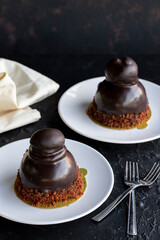 Profiteroles cake on a dark background. Cake with liquid chocolate and profiteroles. Close-up. Vertical view