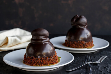Profiteroles cake on a dark background. Cake with liquid chocolate and profiteroles. Close-up. Horizontal view