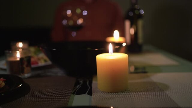 Close-up of burning candles at home on a table during a romantic dinner for valentine's day or anniversary. Zen and relaxation concept.