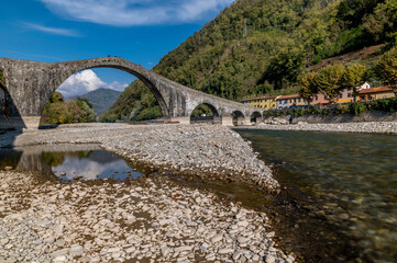 The Serchio River flows under the ancient Ponte della Maddalena, Borgo a Mozzano, Lucca, Italy