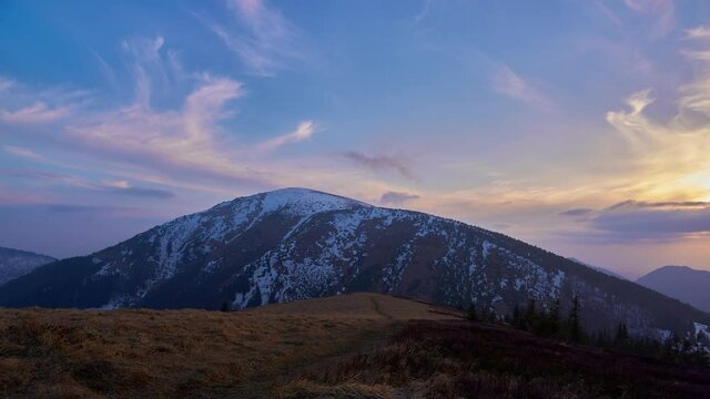 Colorful clouds at sunset, in a spring mountain landscape, melting snow.