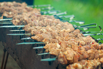 Barbecue cooking on the grill, the meat on the skewers is stacked in a row. Fragrant smoke