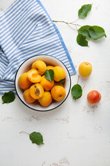 Fresh apricots fruit in bowl on white kitchen table food top view