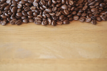 Roasted coffee beans on wood background with selective focus