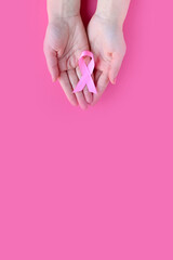 Breast Cancer Awareness. Concept I Am and I Will. Hands of woman holding pink ribbon on pink...