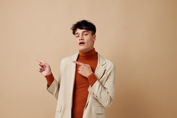 A young man in a beige jacket talking on the phone isolated background unaltered