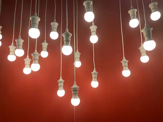 Hanging light bulbs with the depth of field on red background