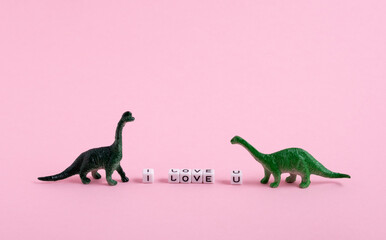 Cute  little green dinosaurs and the inscription I love you on a pink background. Saint Valentine's...