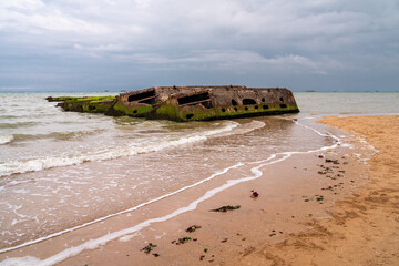 Remains of military artificial port from the world war and landing of allies in Arromanches,...