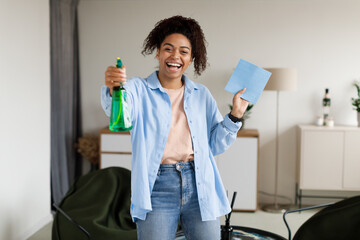 Portrait of black woman cleaning house singing holding rag