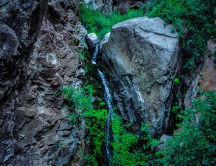 Obraz premium cascada entre roca gigante en un barranco de la jungla
