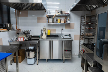 Empty restaurant kitchen. Confectionery shop without people. Concept sale of equipment for restaurant business. Oven and table with built-in refrigerator in restaurant kitchen. Equipment for HoReCa