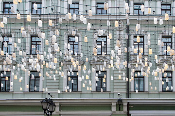 Decorations of Stoleshnikov lane in Moscow. Large garland from electric bulbs hangs above pedestrian street. Clear blue sky in the background. Travel in Russia theme.