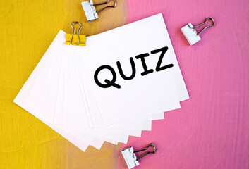 On a multicolored background there is a white plaque with the inscription quiz