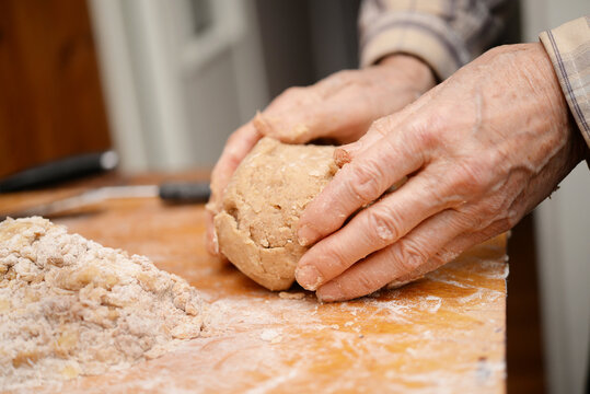 ball of traditional gingerbread dogh in senior man&rsquo;s hands