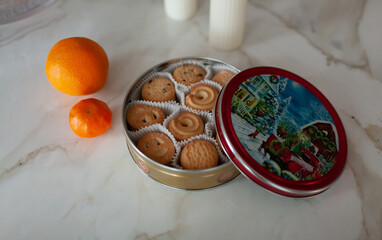 Christmas cookies on white table with oranges and candles