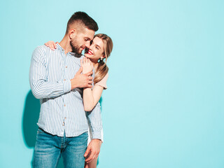 Sexy smiling beautiful woman and her handsome boyfriend. Happy cheerful family having tender moments near blue wall in studio.Pure cheerful models hugging.Embracing each other