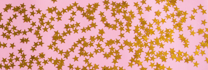Bright colorful confetti stars sparkles on a pink background, the theme of a holiday and a...