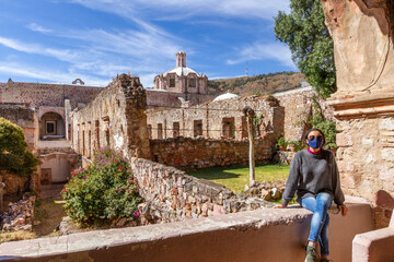 One woman wears facemask inside touristic ruins of a museum in Zacatecas, Mexico - obrazy, fototapety, plakaty