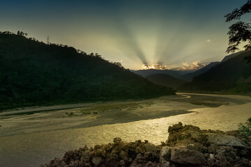 Beautiful sunset over a turn of river Tista or Teesta, Himalayan Mountain range in the background. River Tista is flowing through Sikkim and source of water for many people in Sikkim, India.