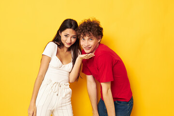 young boy and girl together posing emotions close-up yellow background unaltered