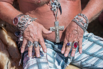 Large silver rings with jewelry stones and skull image on a man hand in a street flea market in...
