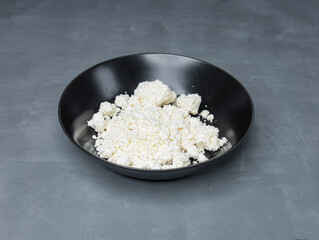 natural cottage cheese in a black plate on a gray table - 478158666