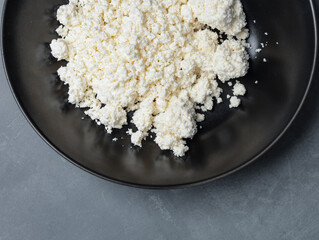 natural cottage cheese in a black plate on a gray table - 478158688