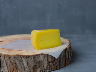 cheese on a wooden stand with paper on a gray background - 478159008