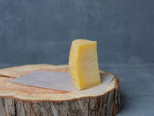cheese on a wooden stand with paper on a gray background - 478159221