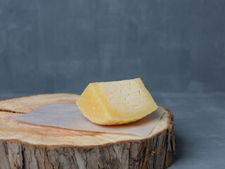 cheese on a wooden stand with paper on a gray background - 478159245