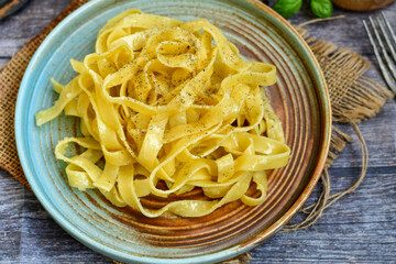 Italian food . Fresh home made  tagliatelle vegetarian  egg pasta  with ,parmesan cheese ,fresh parsley  and black pepper.Pasta cacio e pepe