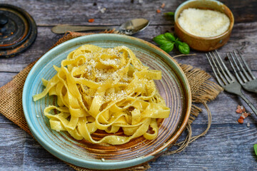 Italian food . Fresh home made  tagliatelle vegetarian  egg pasta  with ,parmesan cheese ,fresh parsley  and black pepper.Pasta cacio e pepe