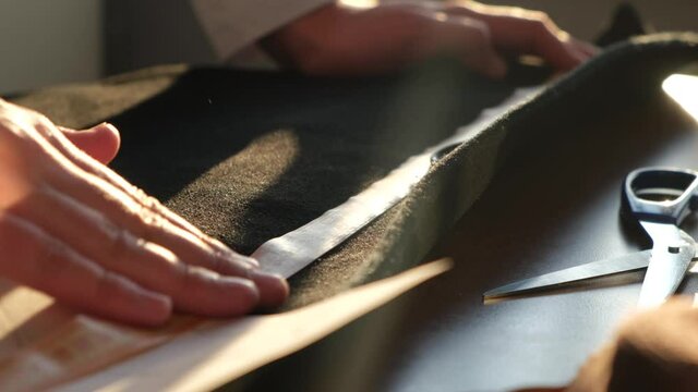 Tailor or clothing designer works with fabric, close-up. Repair of clothes or tailoring of clothes to order