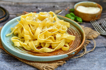 Italian food . Fresh home made  tagliatelle vegetarian  egg pasta  with ,parmesan cheese ,fresh parsley  and black pepper.Pasta cacio e pepe