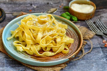 Italian food . Fresh home made  tagliatelle vegetarian  egg pasta  with ,parmesan cheese ,fresh parsley  and black pepper.Pasta cacio e pepe