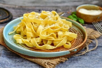 Italian food . Fresh home made  tagliatelle vegetarian  egg pasta  with ,parmesan cheese ,fresh parsley  and black pepper.Pasta cacio e pepe
