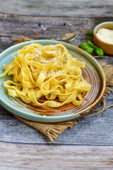 Italian food . Fresh home made  tagliatelle vegetarian  egg pasta  with ,parmesan cheese ,fresh parsley  and black pepper.Pasta cacio e pepe