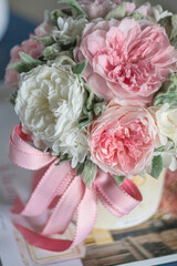 Beautiful spring bouquet in round ceramic vase. Arrangement with Peonies roses. Decorative flowers in a round vase.