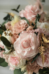 Beautiful preserved flower bouquet in ceramic vase on white table. Stylish bouquet in peach tones closeup.