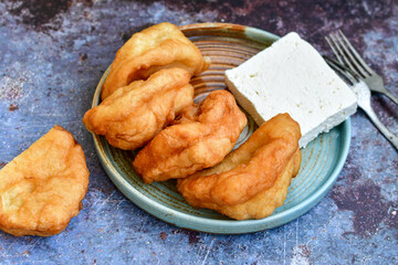 Traditional Bulgarian home made deep fried  patties  covered with sugar  оn rustic backgroud.Mekitsa or Mekica,  on wooden  rustic  background. Made of kneaded dough that is deep fried 
