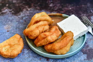 Traditional Bulgarian home made deep fried  patties  covered with sugar  оn rustic backgroud.Mekitsa or Mekica,  on wooden  rustic  background. Made of kneaded dough that is deep fried 