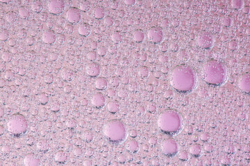 Oil with bubbles on coral background. Pink Abstract space background. Soft selective focus. macro of oil drops on water surface. copy space. air bubbles in water