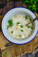 Home made chicken soup with noodles ,parsley and vegetables in white bowl . Healty soup
